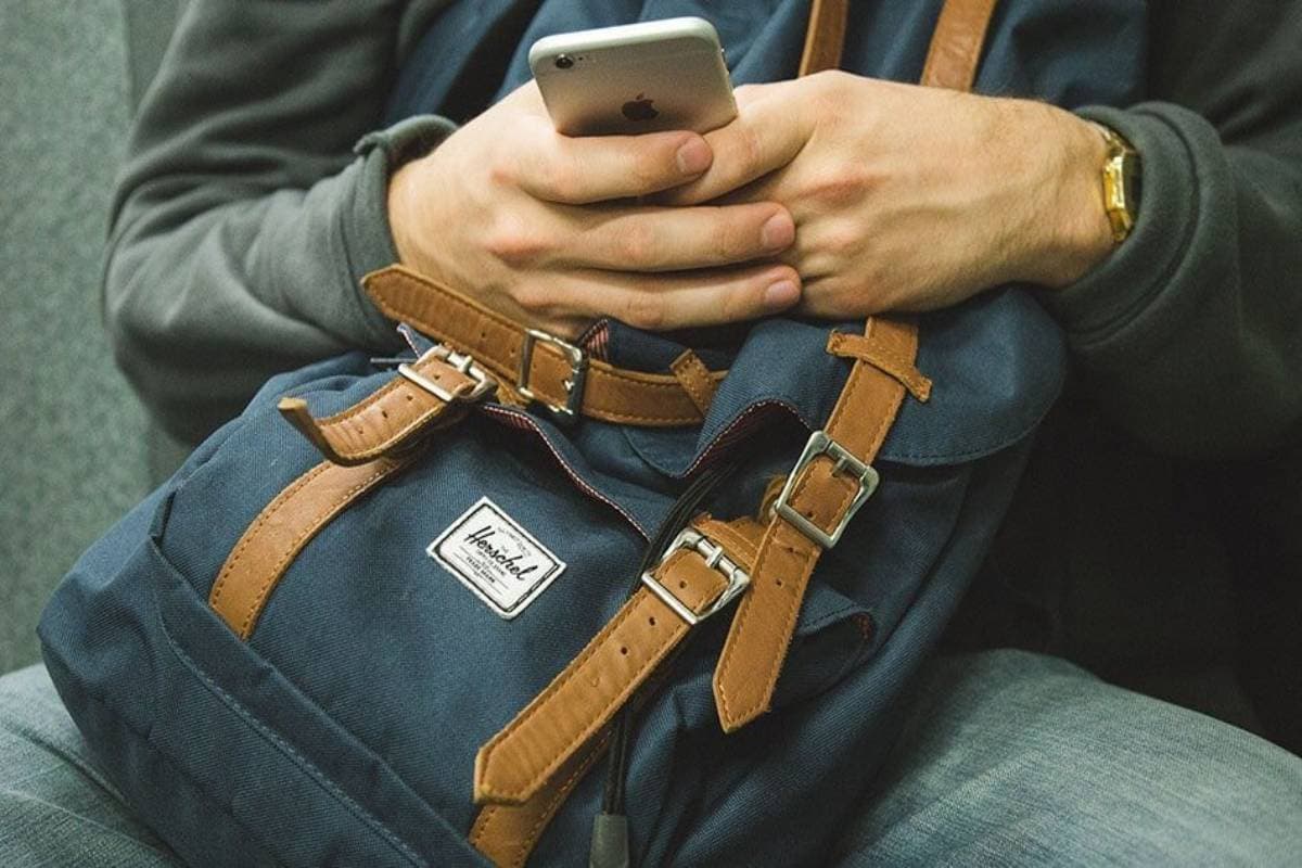 Man with backpack in his lap