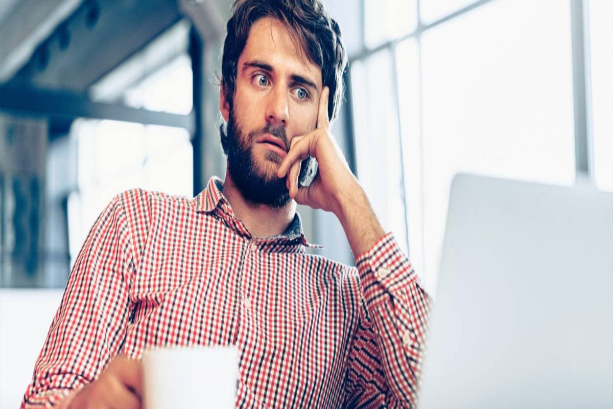 Man at a desk looking confused